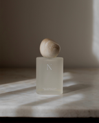 Natural Isle Signature Room Spray Frosted bottle with marble cap on a marble surface
