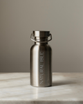 Stainless steel water bottle with 'Natural Isle' branding on a marble surface.